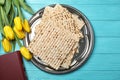 Flat lay composition of matzo, Torah and flowers on wooden background.