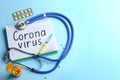 Flat lay composition of medications and notebook with words CORONA VIRUS on blue background. Space for text Royalty Free Stock Photo