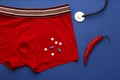 Flat lay composition with men`s underwear and chili pepper on blue background. Potency problem concept