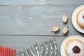 Flat lay composition with menorah, red candles, dreidels including He, Pe, Nun, Gimel letters and sufganiyot on grey wooden table Royalty Free Stock Photo