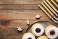 Flat lay composition of menorah, yellow candles, dreidels with He, Pe, Nun, Gimel letters and sufganiyot on wooden table, space Royalty Free Stock Photo