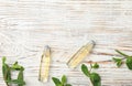 Flat lay composition with mint essential oil on white wooden background