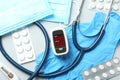 Flat lay composition with modern fingertip pulse oximeter and medical items on background