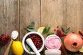 Composition with natural homemade mask, pomegranate and ingredients on wooden table. Space for text