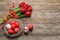 Flat lay composition of nest with painted Easter eggs and flowers on wooden table Royalty Free Stock Photo