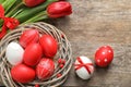 Flat lay composition of nest with painted Easter eggs and flowers on wooden table Royalty Free Stock Photo