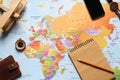 Flat lay composition with notebook and items on world map. Trip planning Royalty Free Stock Photo