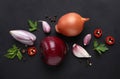 Flat lay composition with onions and spices on black background Royalty Free Stock Photo