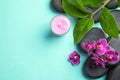 Flat lay composition with orchid and spa stones on turquoise background. Royalty Free Stock Photo