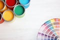 Flat lay composition with paint cans and color palette on wooden background. Royalty Free Stock Photo