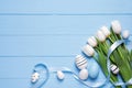 Flat lay composition of painted Easter eggs and tulip flowers on light blue wooden table. Space for text Royalty Free Stock Photo