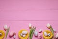 Flat lay composition of painted Easter eggs and tulip flowers on pink wooden table. Space for text Royalty Free Stock Photo