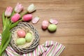 Flat lay composition with painted Easter eggs and tulips on wooden table Royalty Free Stock Photo