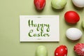 Flat lay composition of painted eggs and card with text Happy Easter Royalty Free Stock Photo