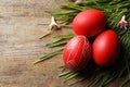 Flat lay composition of painted red Easter eggs and grass on wooden table, space for text Royalty Free Stock Photo