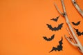 Flat lay composition with paper bats, spiders and wooden branches on orange background, space for text. Halloween decor Royalty Free Stock Photo