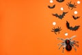 Flat lay composition with paper bats, spiders and golden confetti on orange background, space for text. Halloween celebration Royalty Free Stock Photo