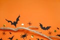 Flat lay composition with paper bats, spiders and wooden branch on orange background, space for text. Halloween decor Royalty Free Stock Photo