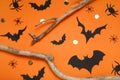 Flat lay composition with paper bats, spiders and wooden branches on orange background. Halloween decor Royalty Free Stock Photo