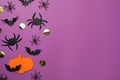 Flat lay composition with paper pumpkin, spiders and bats on purple background, space for text. Halloween celebration Royalty Free Stock Photo