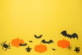 Flat lay composition with paper pumpkins, bats and spiders on pale yellow background, space for text. Halloween celebration Royalty Free Stock Photo