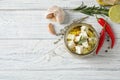 Flat lay composition with pickled feta cheese in jar on white wooden table Royalty Free Stock Photo