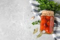 Flat lay composition with pickled tomatoes in glass jar on grey table