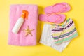 Flat lay composition with pink Beach accessories on yellow color background. Summer holiday background. Vacation and travel items Royalty Free Stock Photo