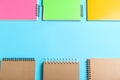 Flat lay composition with plastic and paper notebooks on blue background, space for text. Recycling concept Royalty Free Stock Photo