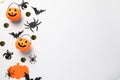 Flat lay composition with plastic pumpkin baskets, paper bats and spiders on white background, space for text. Halloween Royalty Free Stock Photo