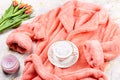 Flat lay composition with plush pink bathrobe, coffee, flowers on marble background, top view, copy space