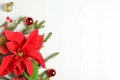 Flat lay composition with poinsettias traditional Christmas flowers and holiday decor on white wooden table. Space for text