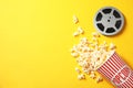 Flat lay composition with popcorn, reel and space for text on color background. Royalty Free Stock Photo