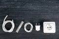 Flat lay composition with power socket, wires, plug and electrical connector on wooden background