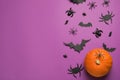 Flat lay composition with pumpkin, spiders and paper bats on purple background, space for text. Halloween celebration Royalty Free Stock Photo