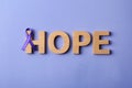 Flat lay composition with purple ribbon and word HOPE. Domestic violence awareness Royalty Free Stock Photo