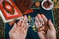 Flat lay composition of Qoran, Dates and tasbih rosary beads on top of a sajadah praying mattress