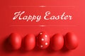 Flat lay composition of red painted eggs and text Happy Easter