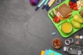 Flat lay composition with serving tray, tasty healthy food and school stationery on grey table. Space for text