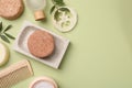 Flat lay composition of solid shampoo bars, loofah and comb on green background. Space for text Royalty Free Stock Photo