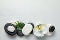 Flat lay composition with spa stones, orchid flower and leaf on white marble table. Space for text Royalty Free Stock Photo