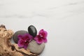 Flat lay composition with spa stones and orchid flowers on white marble table. Space for text Royalty Free Stock Photo