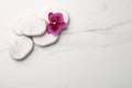 Flat lay composition with spa stones and orchid on white marble table. Space for text Royalty Free Stock Photo