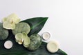 Flat lay composition with spa stones, solid shampoo bar and beautiful flowers on white table. Space for text Royalty Free Stock Photo