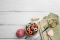 Flat lay composition with spools of threads and sewing tools on white wooden table, space for text Royalty Free Stock Photo