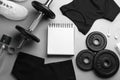 Flat lay composition with sportswear, notebook and equipment on grey table. Gym workout plan Royalty Free Stock Photo