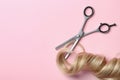 Flat lay composition with strand of blond hair, thinning scissors on color background. Royalty Free Stock Photo