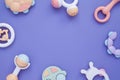 Flat lay composition with baby rattles set in pastel colors and space for text on lilac background. Royalty Free Stock Photo