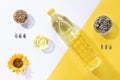 Flat lay composition of sunflower oil with bowls of sunflower seeds on white and yellow background Royalty Free Stock Photo