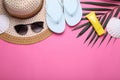 Flat lay composition with sunscreen and beach accessories on pink background. Space for text Royalty Free Stock Photo